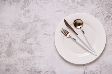 Clean empty white plate with cutlery.