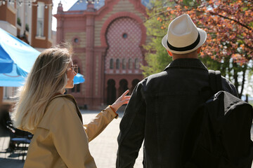 Canvas Print - Couple of tourists walking on city street