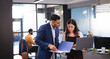 © Wavebreak Media - Two diverse male and female business colleagues using laptop and talking