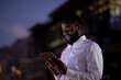 © Wavebreak Media - African american businessman working at night using smartphone