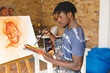 © Wavebreak Media - African american male painter at work painting portrait on canvas in art studio