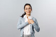 Portrait of touched, flattered young woman, teacher or office worker in glasses, hold hands on heart impressed with ncie gesture of coworker, smiling and sighing, look thankful and pleased