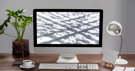 Digital composition of binary coding data processing on computer screen on wooden table