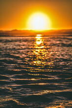 Vertical Shot Of A Bright Sunset Sun Reflected On Calm Ocean During A Golden Hour