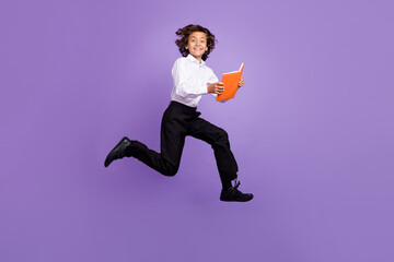 Poster - Full body photo of cool small brunet boy run read book wear shirt trousers sneakers isolated on purple color background