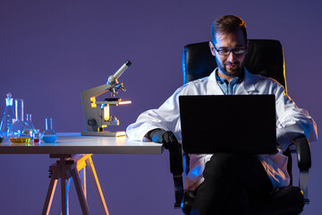 Poster - laboratory technician looks into laptop and smiles. laboratory technician uses computer. microscope 