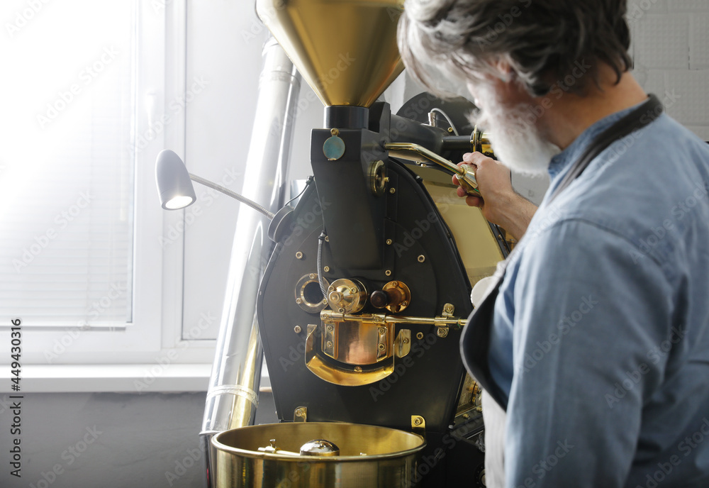 Senior man using modern coffee roaster