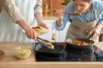 Young couple cooking in kitchen