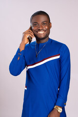 Wall Mural - handsome, happy young african man smiling while making a phone call