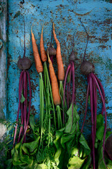 Wall Mural - Carrots and beets - root vegetables on an old turquoise textured background. Summer farm vegetables. Vertical