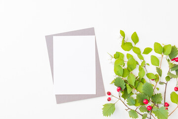 Wall Mural - flat lay mockup blank paper sheet card with red berries and green leaves on white background