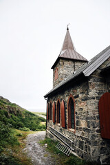 Wall Mural - Grense Jakobselv. Cloudy morning in small village in Finnmark county on the shore of the Barents Sea on a foggy day. Arctic Northern Norway landscapes. King Oscar II Chapel. Norwegian stone church