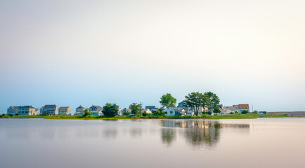 Wall Mural - Warm glowing sea and sky at sunrise over the beach village in Boston area