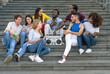 © Alessandro Biascioli - Young multiracial friends having fun listening music with vintage boombox stereo and using mobile smartphone while sitting on urban stairs - Youth millennial lifestyle concept