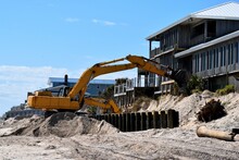 Backhoe Working On Beach Erosion Background At Ocean Beach St. Augustine, Florida.