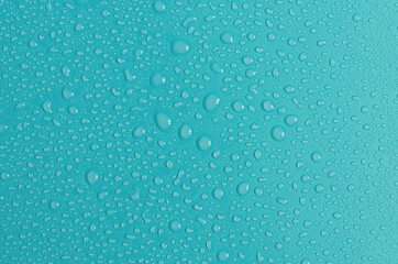  Blue-green background with large and small water drops. The texture of a water drop on a colored background is a top view.