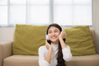 © Chanakon - Relaxing time on sofa. Beautiful young asian woman lay down on sofa and listening to the music with headphone. She has rhythm Lifestyle in living room at house in the morning.