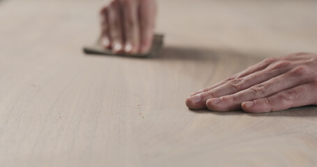 Poster - man hand sanding black walnut wood table
