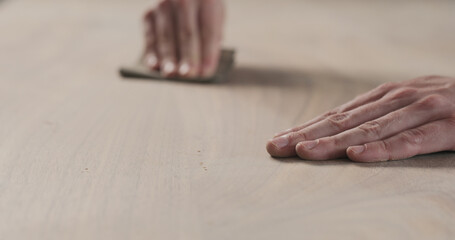 Wall Mural - man hand sanding black walnut wood table