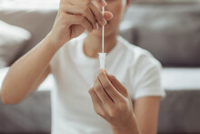 Woman self test for COVID-19 home test kit. asian woman using coronavirus covid-19 rapid antigen home testing kit, Coronavirus nasal swab test for infection.