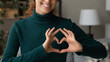 © fizkes - Cropped close up smiling grateful woman showing heart sign, gesture, expressing love and care, happy thankful young female volunteer supporting sick people, regular medical checkup promotion