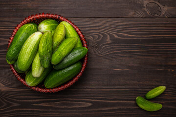 Wall Mural - fresh cucumbers in a basket on a wooden table