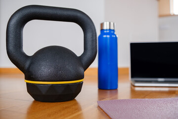 Home exercise kit with kettlebell and a laptop.