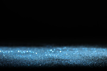 Wall Mural - shiny blue glitter on black background, space for text. bokeh effect