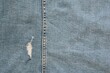 worn denim with one torn hole and vertical seam for background or wallpaper