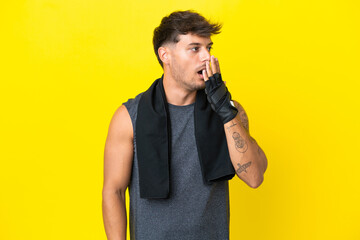 Wall Mural - Young sport caucasian man with towel isolated on yellow background yawning and covering wide open mouth with hand