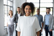 © fizkes - Portrait of smiling young African American female employee or worker forefront satisfied with new job position. Happy millennial ethnic biracial woman pose in office. Diversity, employment concept.