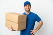 © luismolinero - Delivery man over isolated white background posing with arms at hip and smiling