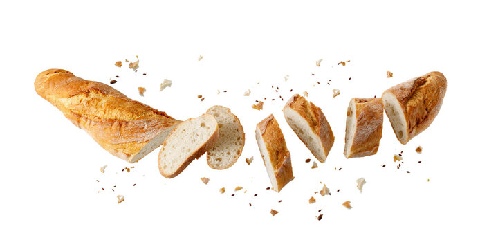 Cutting fresh baked loaf wheat baguette bread  with crumbs and seeds flying isolated on white