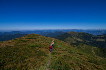  A group of hikers going down the mountainside. Tourism, vacation activity, hiking, backpacking, outdoor. National Take a Hike Day on November 17th