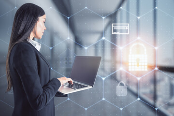 Poster - Attractive young european businesswoman using laptop computer on blurry office interior background with digital honeycomb interface. Digital security, online payment and protection concept. 