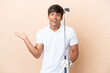 Young golfer player man isolated on ocher background with shocked facial expression