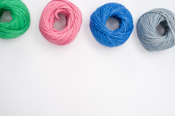 Sticker - Closeup shot of soft colorful textile balls of wool on a white background with a copy space