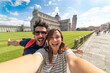 Travel tourists friends taking photo selfi with smartphone in Pisa, Tuscany. happy couple in love traveling in Europe having fun taking self-portrait picture in Pisa by Leaning Tower of Pisa, Italy.