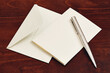 © Tetra Images - Envelope and pen on wooden table