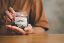 Man Holding Money Jar With DONATE Word Written Text Label For Giving And Donation Concept, Saving, Fundraising Charity, Coronavirus Economic Stimulus Rescue Package