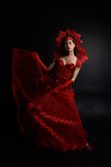 Poster - portrait of beautiful young asian woman wearing red corset, posing in gothic horror style with creative hand gestures isolated against  studio background.