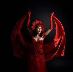 Sticker - portrait of beautiful young asian woman wearing red corset, posing in gothic horror style with creative hand gestures isolated against  studio background.
