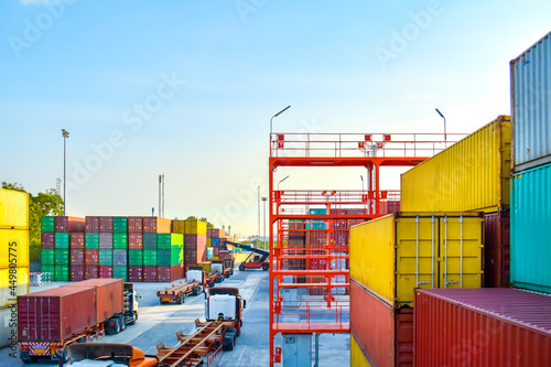 High angle view of container yard operation, heavy equipment reach stacking loading up container to truck and trailer. Container shipping, logistics, transportation, and supply chain.