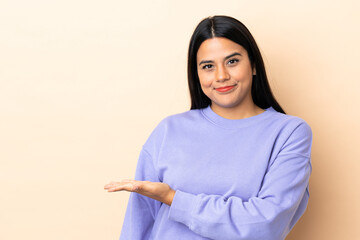 Wall Mural - Young latin woman woman over isolated background presenting an idea while looking smiling towards