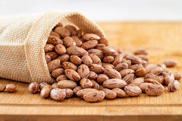 Raw Organic cranberry bean on wooden background.