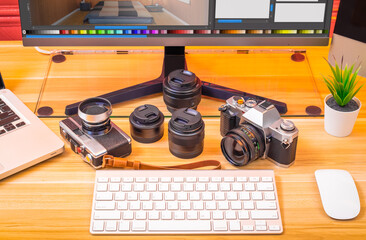 camera and lens with computer on desk, digital photo editing concept