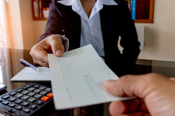 Wall Mural - Business person hand giving cheque.