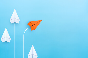 Wall Mural - Business concept for new ideas creativity and innovative solution, Group of white paper plane in one direction and one orange paper plane pointing in different way, copy space