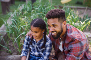 Wall Mural - Happy young man with small sister spending time outdoors in backyard, laughing.