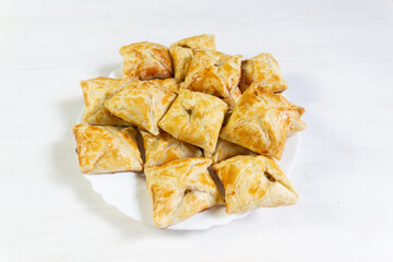 Filled with ground meat square shape pies on white background